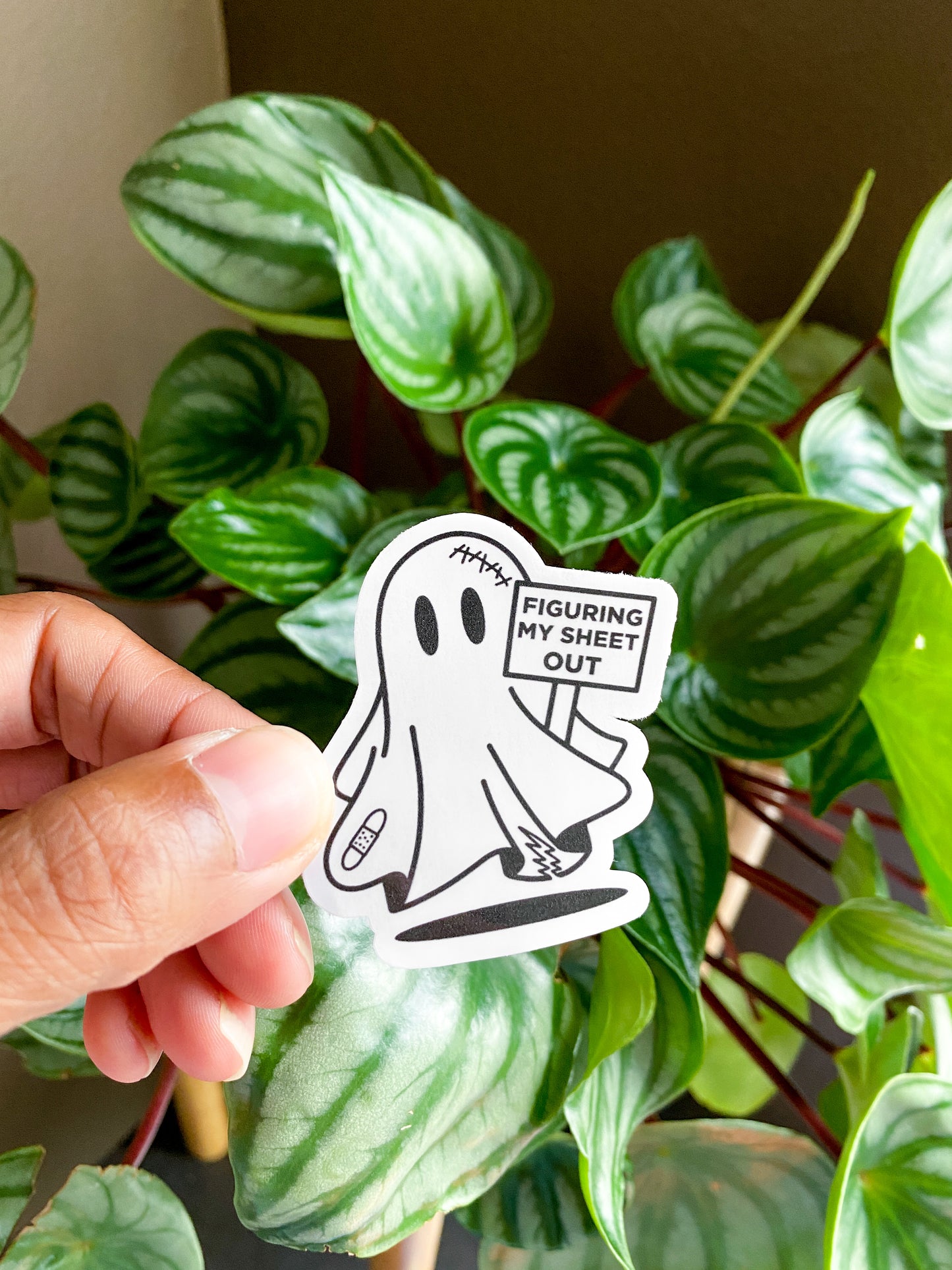 Single spooky ghost holding sign that reads "figuring my sheet out"