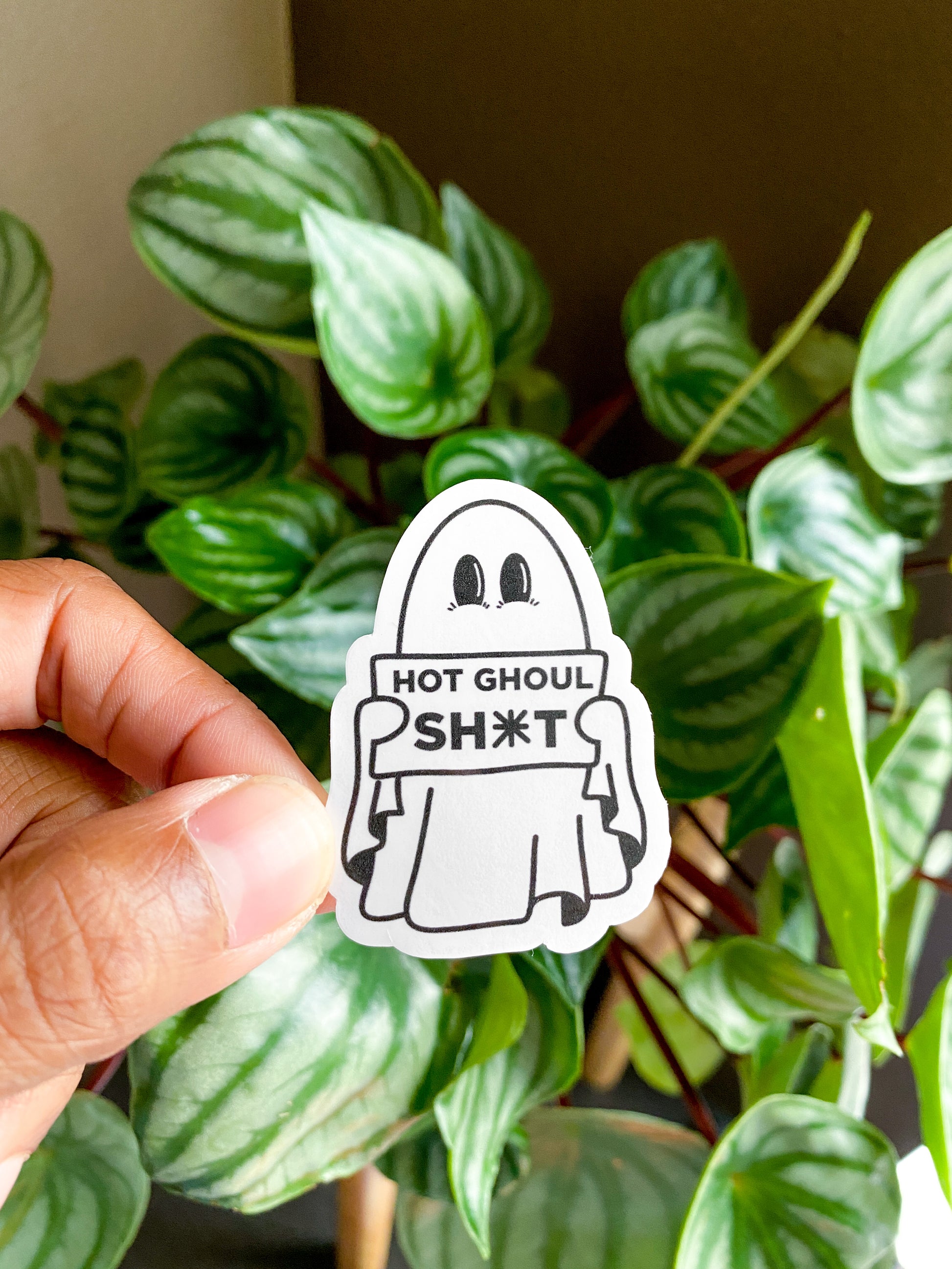 Single Hot Ghoul sticker of little ghost with big eyes holding sign that reads "hot ghoul sh*t"